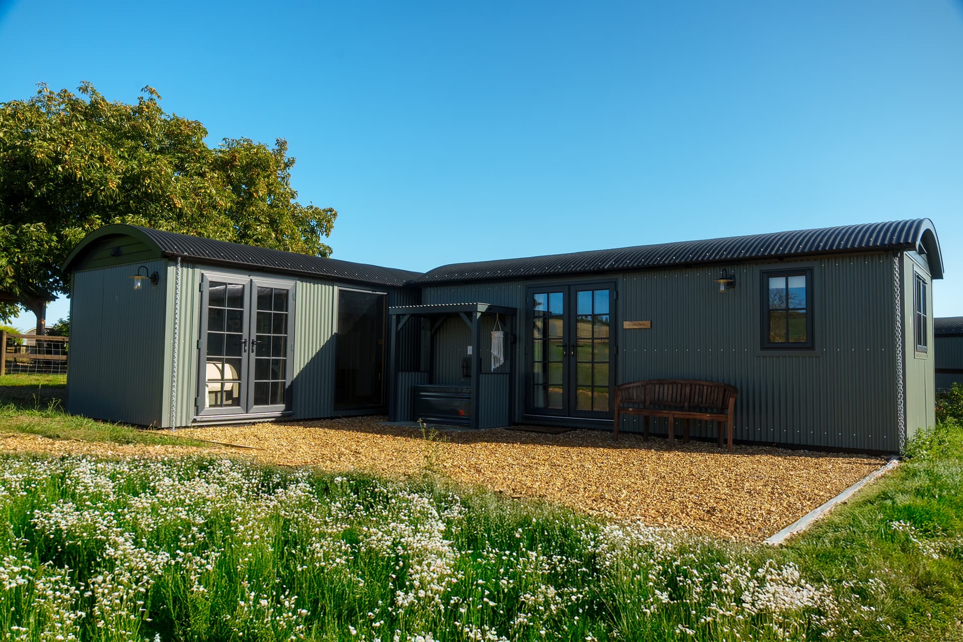 The Meadow Suite from outside, doors open onto the wildflower meadow