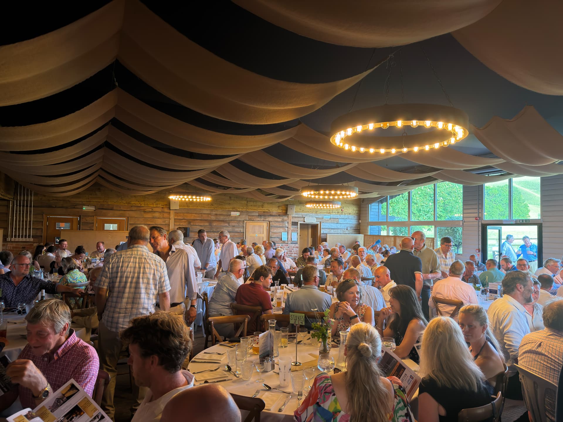 Guests with drinks on the south facing terrace outside the barn