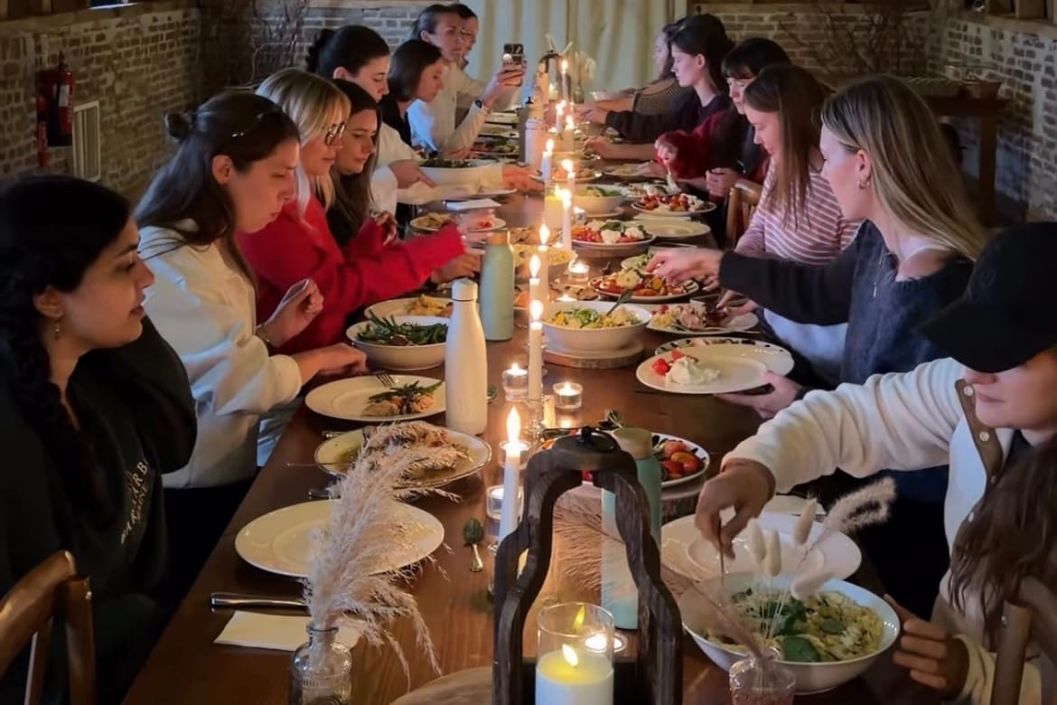 A retreat group gathered along the long candlelit table inside Wellington Barn