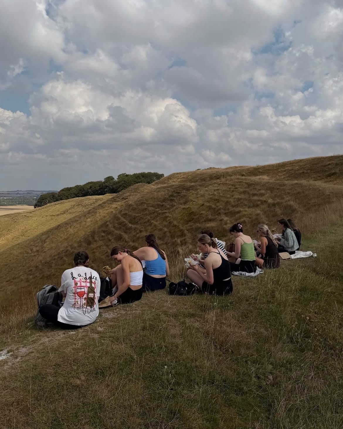 The group sitting together on the slope of the Downs under a big sky